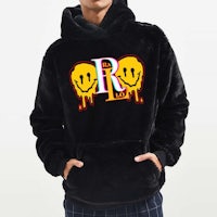 a man wearing a black hoodie with a smiley face on it